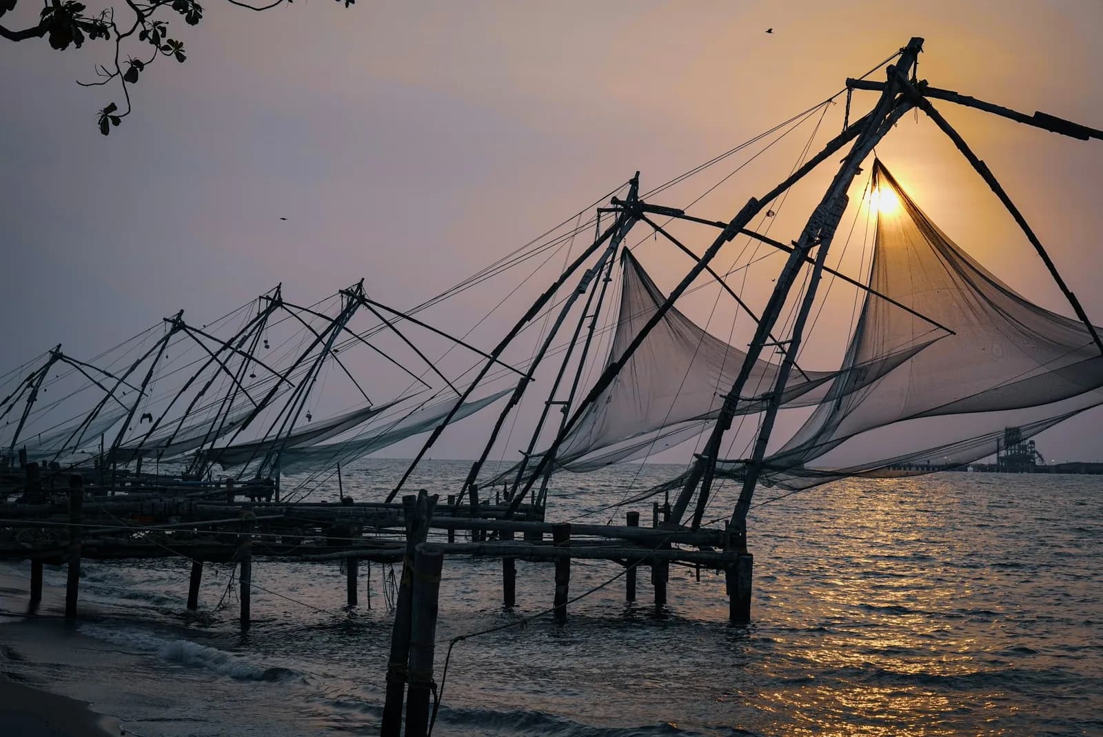 Chinese fishing nets silhouetted against the setting sun at Fort Kochi