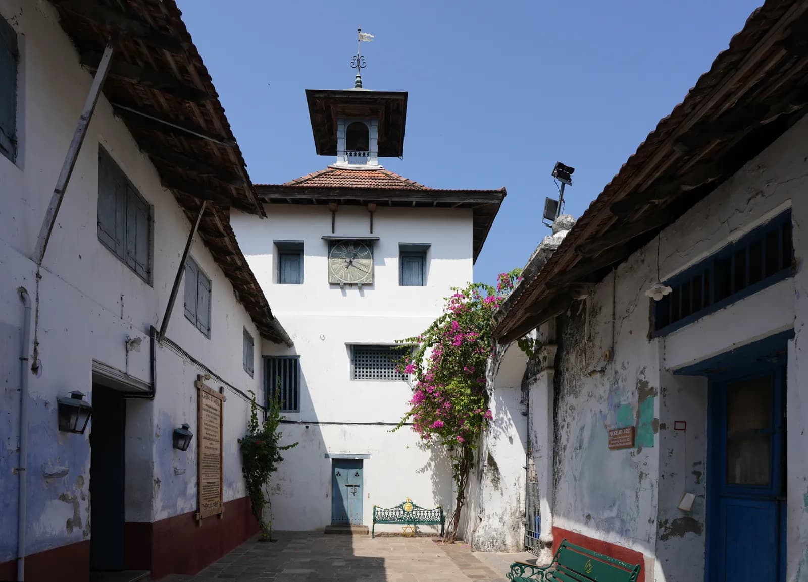 Clock tower of the Paradesi Synagogue in Jew Town, Mattancherry, framed by bougainvillea