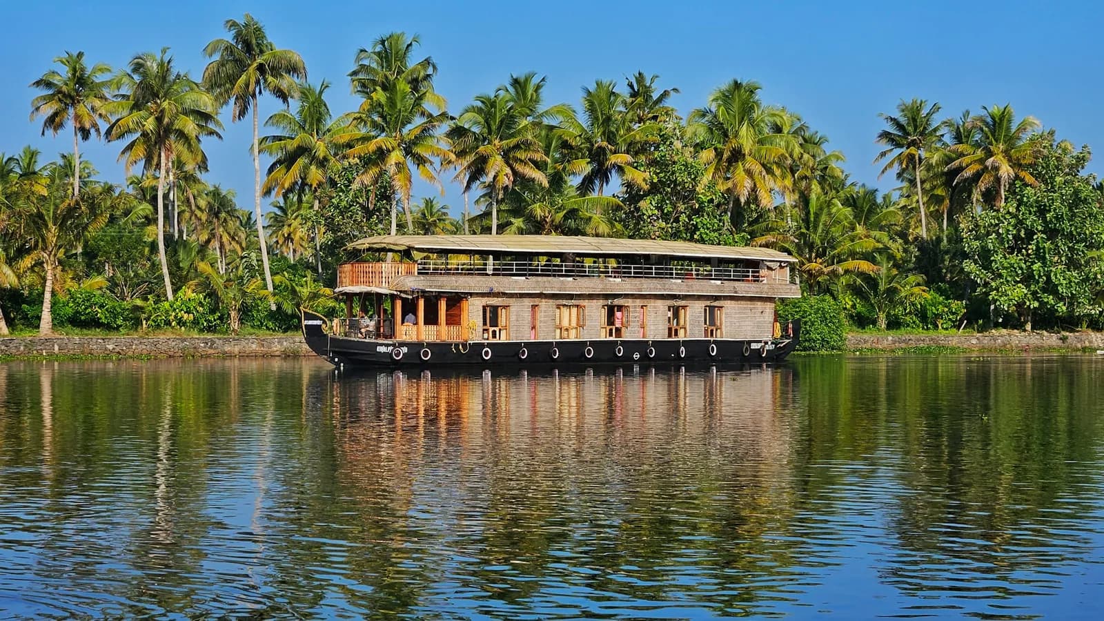 Houseboat moored beneath coconut palms on the Kumarakom backwaters