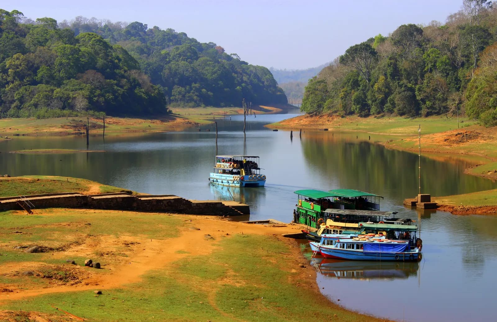 Safari boats moored on Periyar Lake framed by forested hills in Thekkady